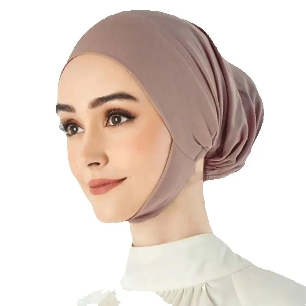 Une femme portant un hijab uni mauve avec une chemise à col blanc.