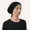 Eine Frau trägt ein schwarzes Hijab mit silbernem Strassrand und einem schwarzen Shirt.