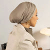 Femme portant un hijab beige instantané et un blazer beige clair, vue de profil.