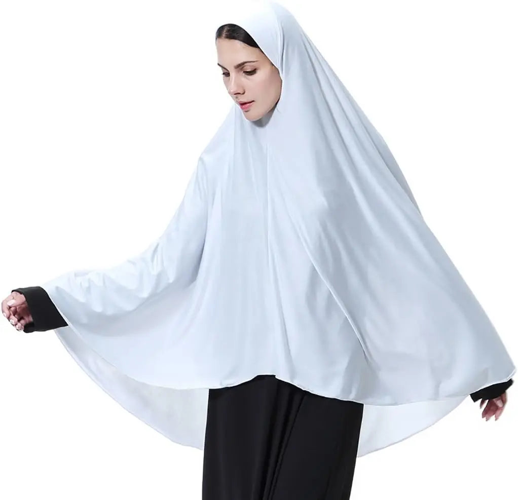 Una mujer vistiendo un elegante pañuelo ligero y blanco y ropa negra.