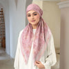 Eine Frau trägt einen rosa Blumenmuster-Voile-Hijab und ein weißes Oberteil.