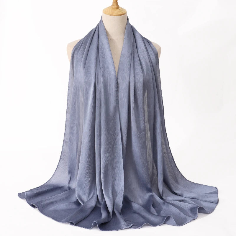 Helles blaues Satin-Crinkle-Hijab-Schal, um den Hals eines Mannequins gewickelt.