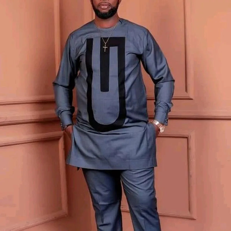 Un homme portant un costume de mariage musulman traditionnel africain bleu foncé avec un design noir et or.