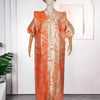 A woman wearing an orange satin abaya kaftan with intricate patterns, displayed on a mannequin.