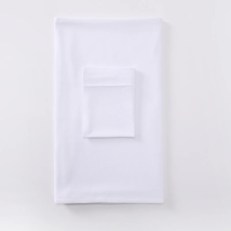 Un conjunto de pañuelo deportivo a juego de dos piezas blanco, doblado cuidadosamente sobre una superficie clara.