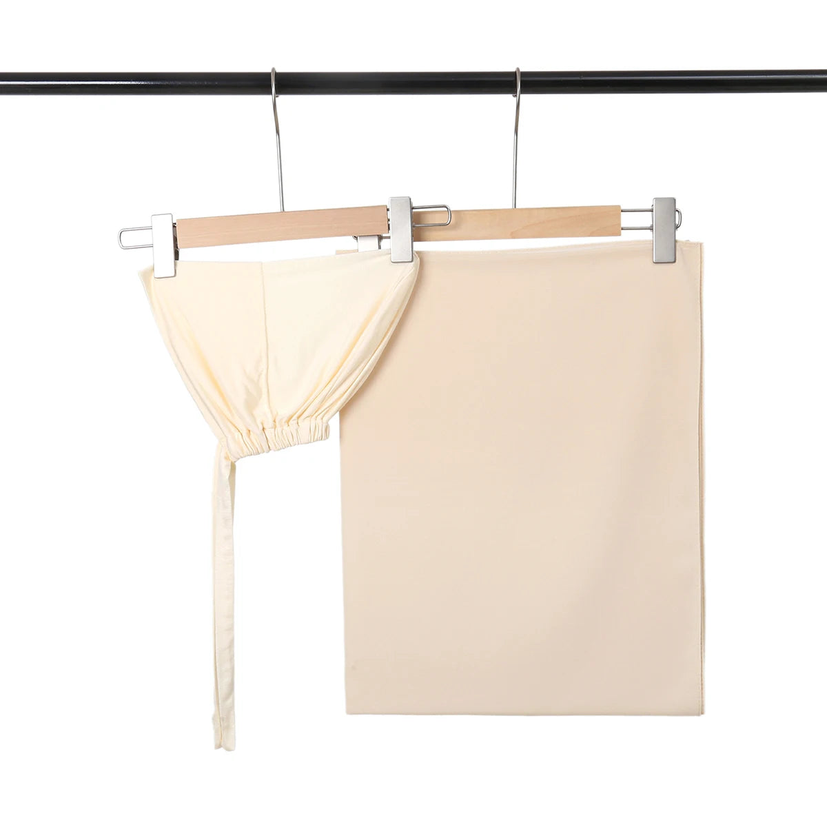 Helles beige Chiffon-Hijab und Untercap-Set, aufgehängt an einem schwarzen Stab.