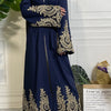 Una abaya kaftan de lujo azul marino con bordado dorado, exhibida en un maniquí.