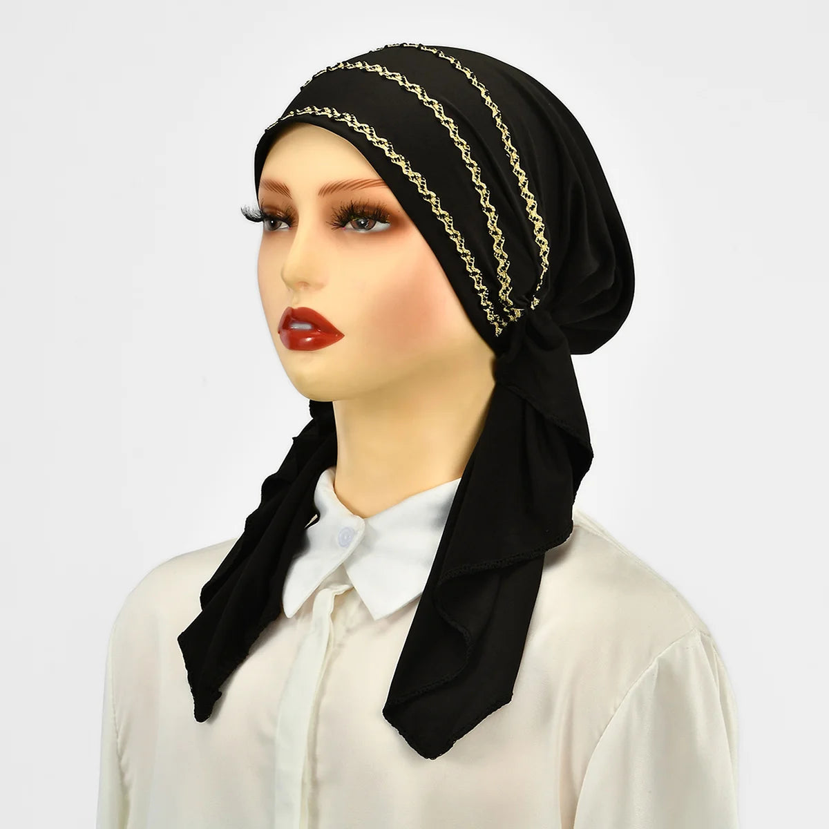 Eine Frau modelliert einen schwarzen Hijab mit goldenen Streifen und Elastik über einem weißen Shirt.