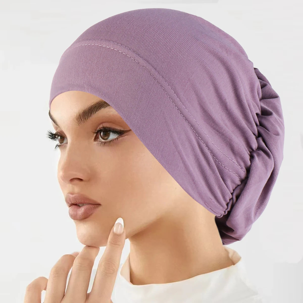 Nahaufnahme einer Frau, die eine lila Stretch-Turbanmütze trägt.