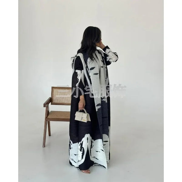 A woman is modeling a black and white retro printed pleated windbreaker jacket.