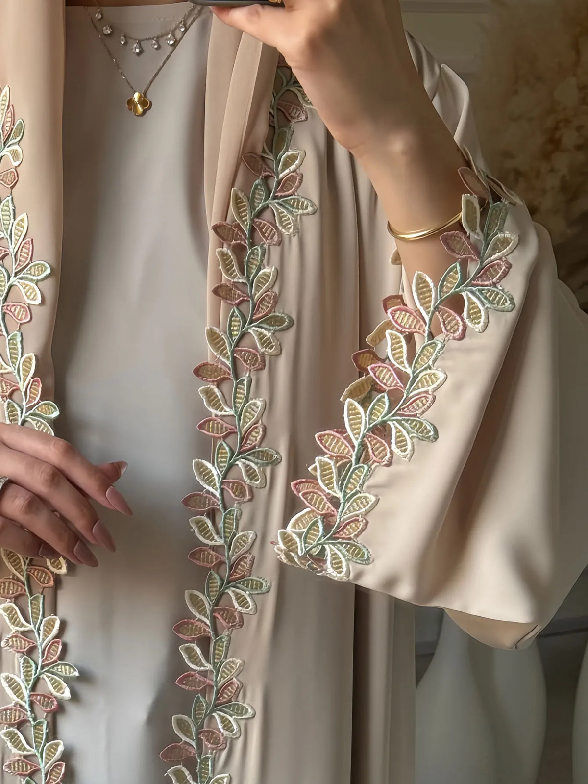 Elegante beige Abaya mit dezter rosa und grüner Blattstickerei am Ärmel.