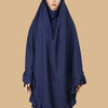Eine Frau trägt einen marineblauen, mit gerafften Rändern verzierten, strassbesetzten muslimischen Hijab.