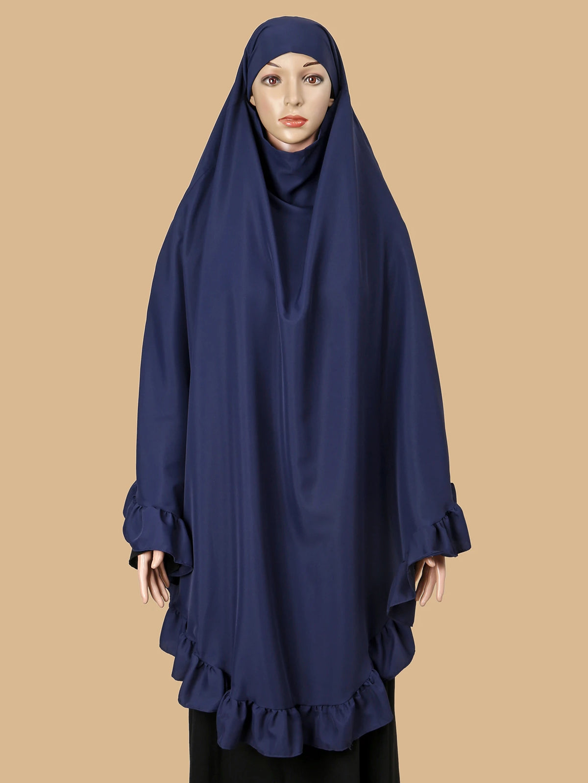 Eine Frau trägt einen marineblauen, mit gerafften Rändern verzierten, strassbesetzten muslimischen Hijab.
