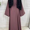Mauve Maxi Abaya Kleid mit schwarzem Zierrand und Ärmeln auf weißem Hintergrund.