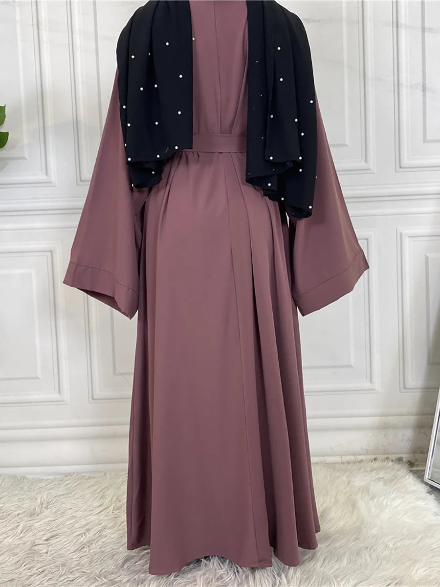 Mauve Maxi Abaya Kleid mit schwarzem Zierrand und Ärmeln auf weißem Hintergrund.