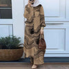 Una mujer vistiendo un conjunto de abaya de manga larga con estampado beige, de pie frente a una puerta blanca.
