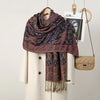 Dunkelviolett-braches Paisley-Viskose-Hijab-Schal über einem cremefarbenen Mantel.