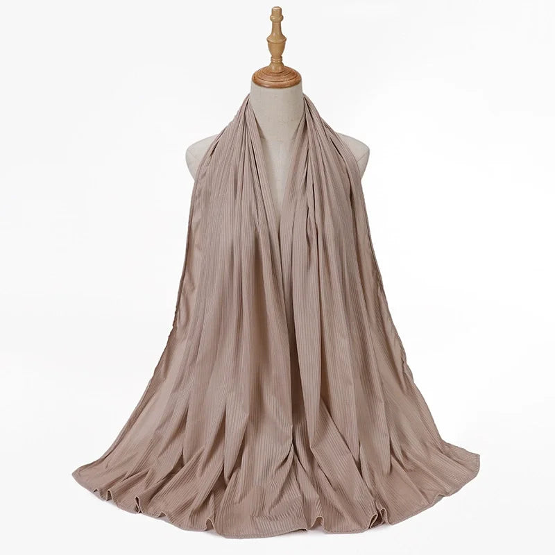 Bufanda de jersey de algodón de hilo beige drapeada alrededor del cuello de un maniquí.