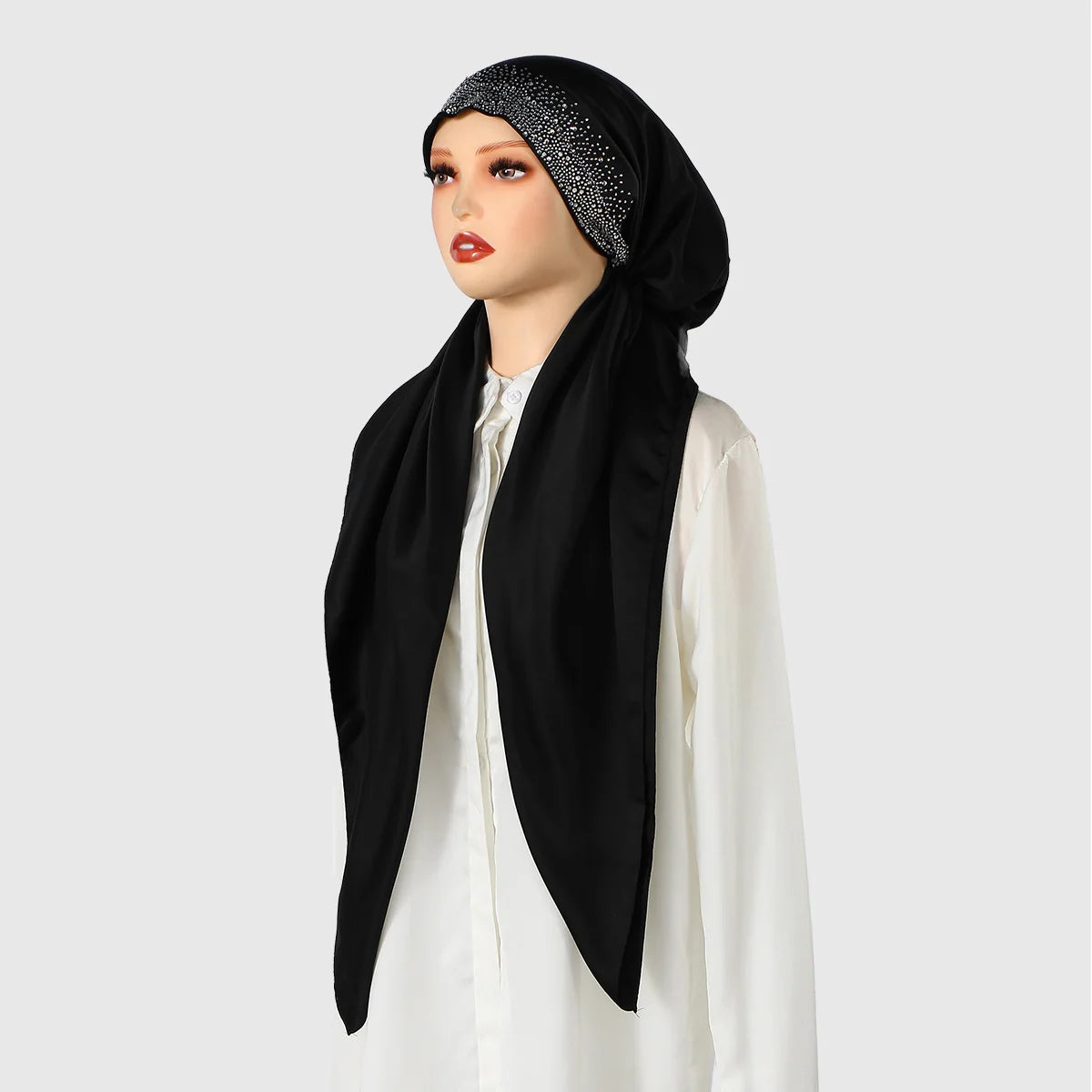 Eine Frau modelliert einen schwarzen Seiden-Instant-Hijabschal mit einem glitzernden schwarzen Stirnband und einem weißen Obe