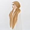 Una mujer usando una diadema de elástico de diamantes beige para hijab con una blusa blanca.