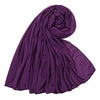 Un foulard hijab en jersey de coton violet profond, roulé et drapé, montrant sa texture douce.