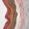 Exhibición vertical de pañuelos de chifón arrugado y brillante en tonos rosa apagado, beige y topo.