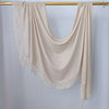 Hijab de malla beige con estampado doble, drapeado sobre un perchero de madera.
