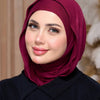 Eine Frau trägt einen tiefmaronen, sofort einsatzbereiten Jersey-Hijab und ein schwarzes Oberteil.