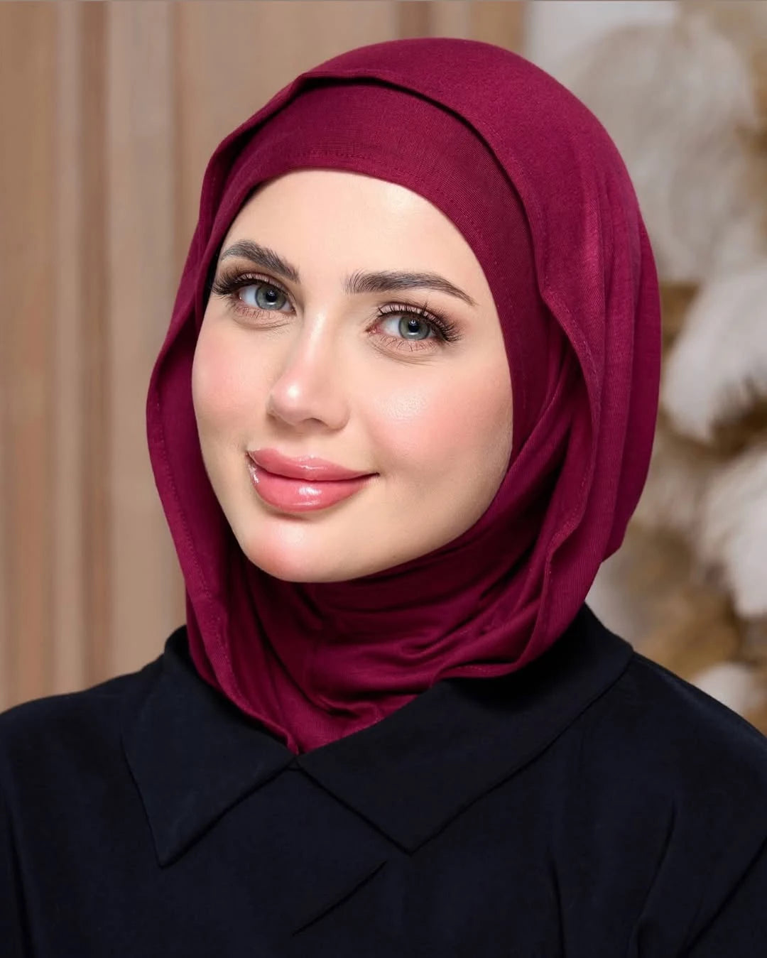 Eine Frau trägt einen tiefmaronen, sofort einsatzbereiten Jersey-Hijab und ein schwarzes Oberteil.
