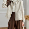 Une femme portant un manteau en laine beige sur un col roulé blanc et un pantalon marron.