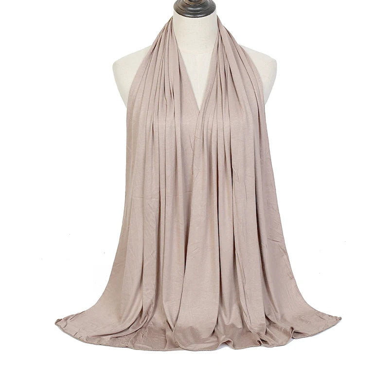 Fließender, drapierter Hijab-Schal aus hellem beige-farbenem Modal-Baumwollstoff auf einem Mannequin.