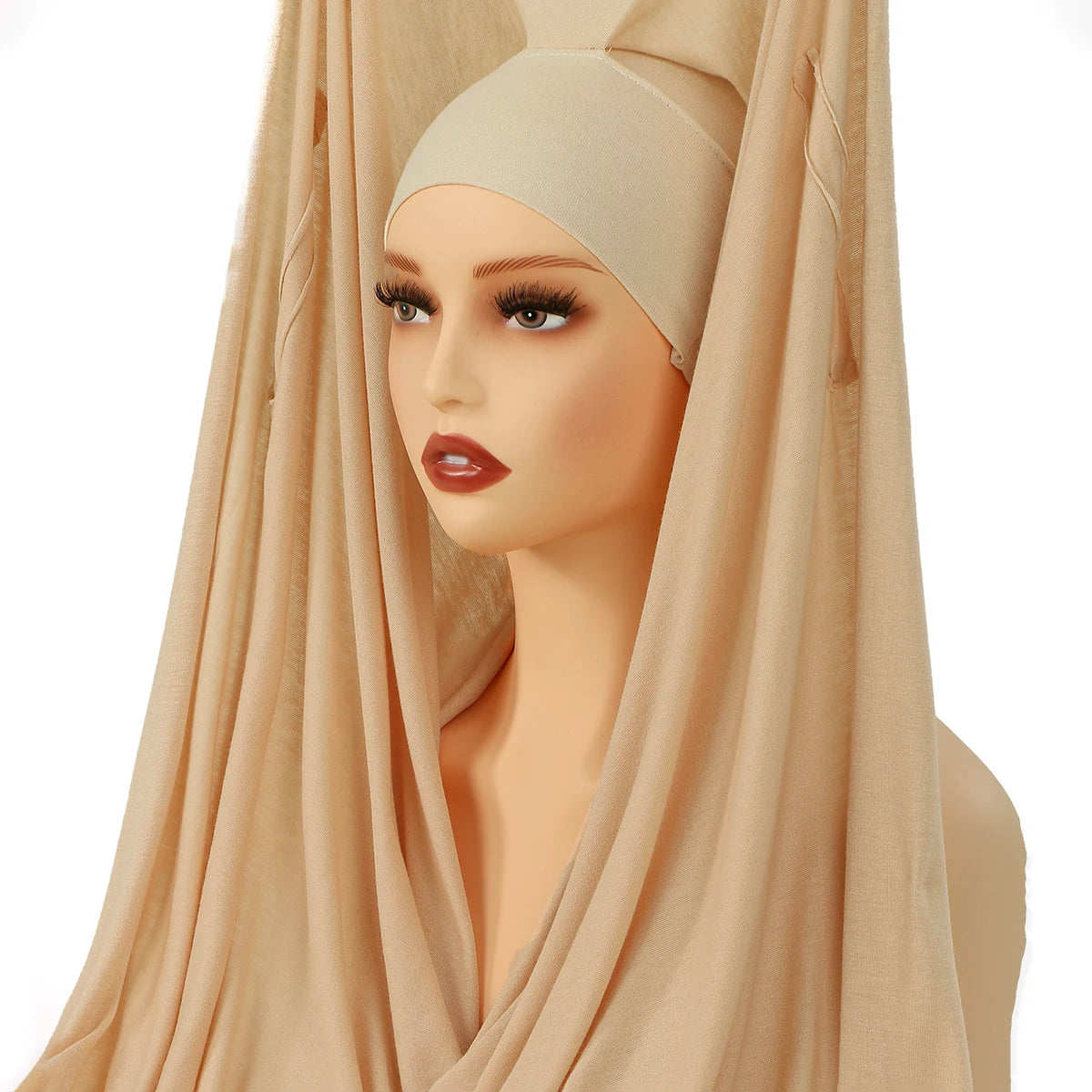 Model trägt ein beige elegantes Modal-Jersey-Hijab, drapiert über Kopf und Hals.