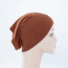 Terrakotta-braune Bambus-Jersey-Turban-Kappe auf einem Mannequin-Kopf.