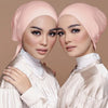 Dos mujeres vistiendo elegantes turbantes de modal rosa y tops de satén a juego