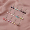 Collection de foulards hijab perles et gemmes multicolores avec boucles métalliques décoratives sur tissu rose.