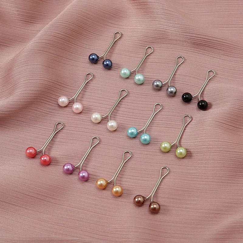 Collection de foulards hijab perles et gemmes multicolores avec boucles métalliques décoratives sur tissu rose.