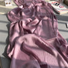 Ein pinkes, gewelltes Crinkle-Satin-Chiffon-Hijab-Stoff in sanftem Sonnenlicht.