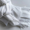 Une pile de foulards de hijab en viscose coton doux blancs avec pompons