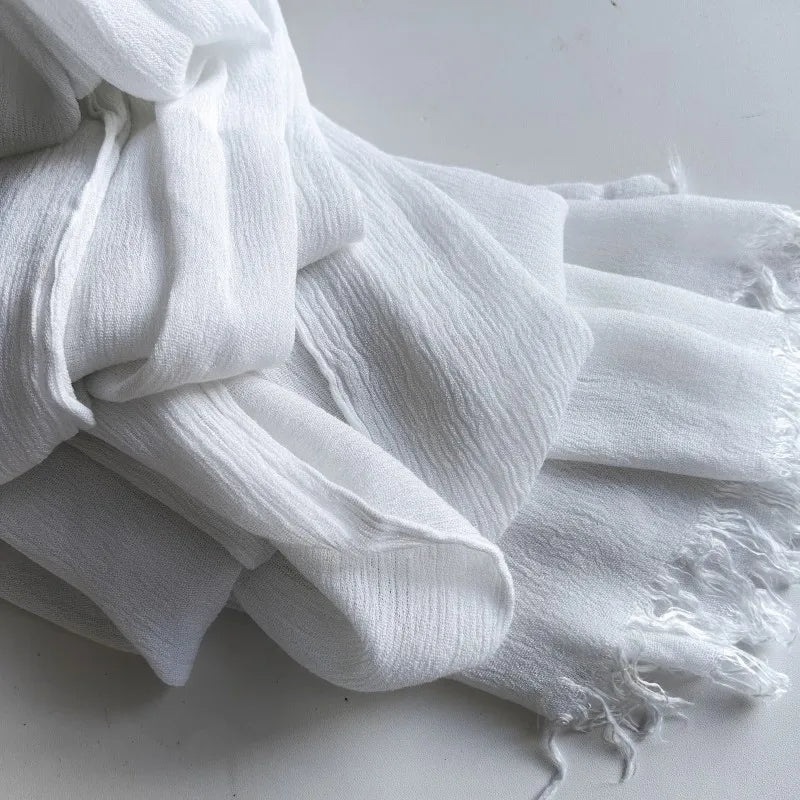 Une pile de foulards de hijab en viscose coton doux blancs avec pompons