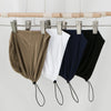 A display of four adjustable modal hijab caps in olive green, white, navy blue, and black hanging from a wooden rack.