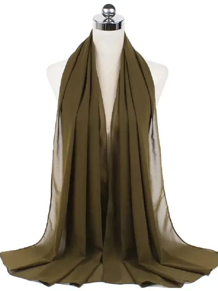 Ein drapierter olivgrüner Chiffon-Hijab-Schal auf einem Mannequin-Hals.