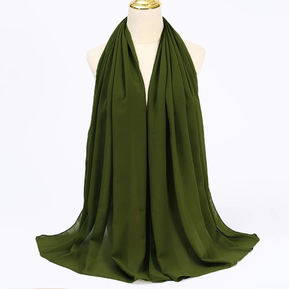 Ein drapierter olivgrüner Chiffon-Hijab-Schal auf einem Mannequin.