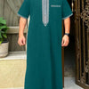 A dark teal Moroccan men's ethnic thobe with a stand collar and white embroidery, displayed in an entryway.
