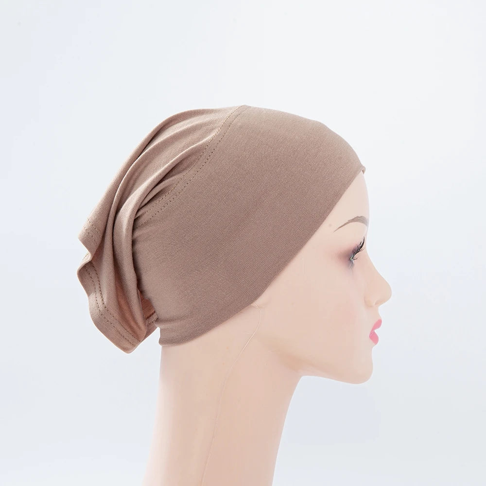 Beige Bambus-Jersey-Turban-Kappe auf einem Mannequin-Kopf.