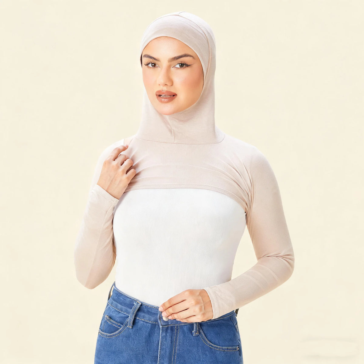 Eine Frau trägt eine beige elastische Modal-Jersey-Oberjacke mit Langarm und Jeanshosen.