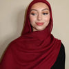 Eine Frau trägt einen tiefroten Gradient-Rayon-Modals-Hijab und schwarze Kleidung.