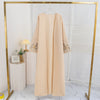 Beige Maxi-Abaya mit Blumenstickerei auf goldener Kleiderstange.