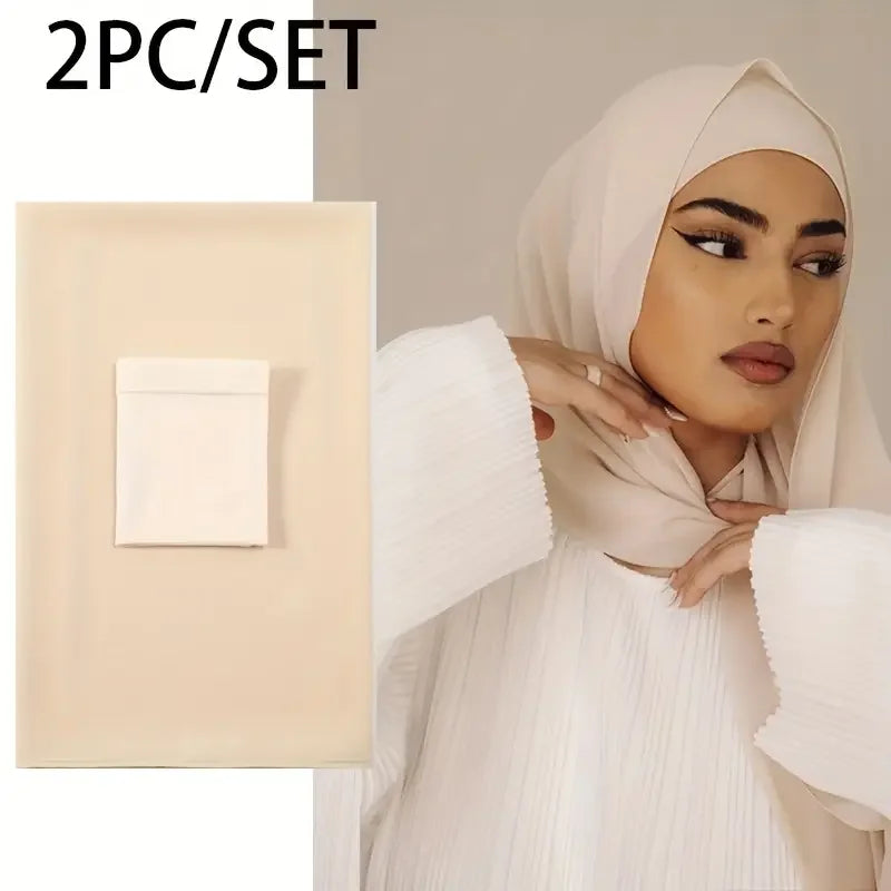 Eine Frau trägt einen beige Chiffon-Hijab und ein passendes Zweiteil-Set mit einem quadratischen Kosmetikartikel.
