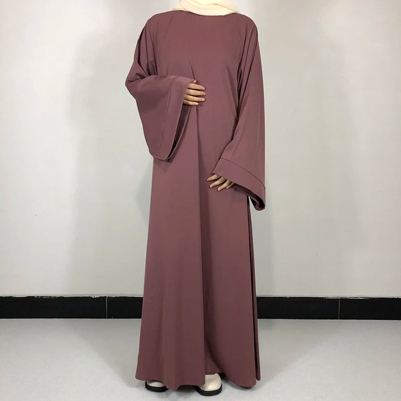 Une abaya mauve uni portée par un mannequin, à manches longues et avec ceinture libre.
