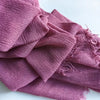 Une pile de foulards de hijab en viscose coton rose poudré avec pompons